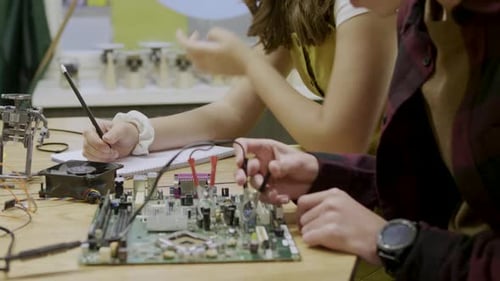 Teenagers Working on Computer Hardware Project Together Indoors