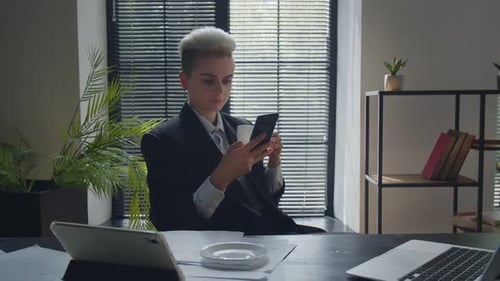 Office Worker Drinks Her Coffee When Texting Message Indoors Business Lady Take a Break and Surfing