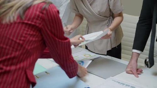 Business Team Reviews Analytics Reports in Modern Office