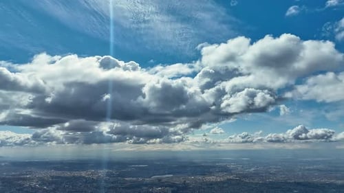 Aerial View: Puffy Clouds Over Expansive Urban Cityscape