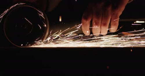 Un soldador limpia las costuras del metal con herramientas eléctricas manuales. Vídeo en cámara lenta
