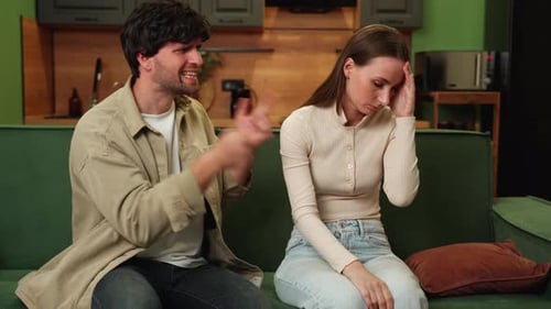 Young Quarreling Sad Couple a Man Shouting at a Woman A Couple Quarrels While Sitting on a Green