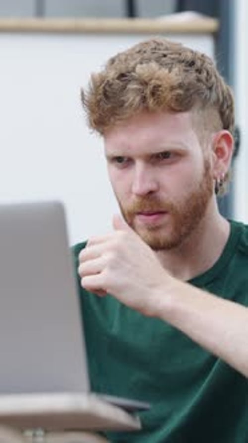 Young Man Working at Laptop Computer Indoors