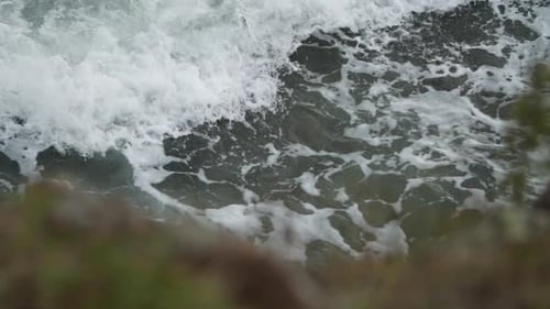 Incoming beautiful wave with blurry rock in the foreground.