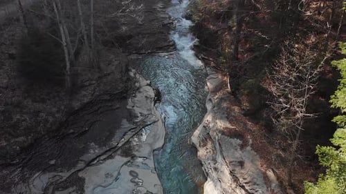 Aerial view of a mountain river with beautiful waterfall in the afternoon sunlight