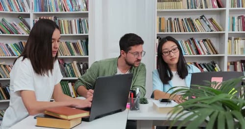 Students Collaborate on Laptops in University Library