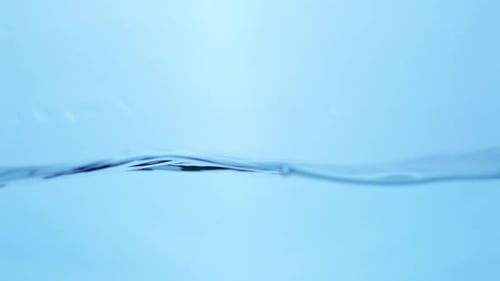 Crystal-clear water swirls smoothly, reflecting light as bubbles rise, representing freshness, fluid