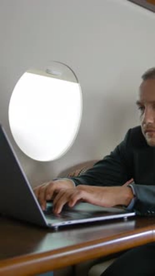 Man Working on Laptop in Private Jet