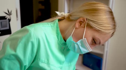 Health Professional in Turquoise Scrubs and Surgical Mask