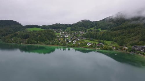 Aerial Views Capture Fuschlsee in Austria with Clouds Mirroring on the Lake's Surface Majestic Alps