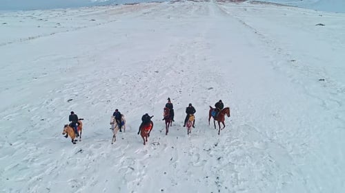 Group of Horseback Riders on a Snowy Plain