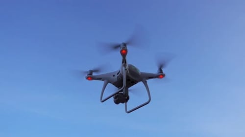 Quadcopter-Drohne, die auf Himmelshintergrund schwebt und fliegt