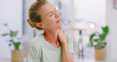 Woman Massages Neck in her Bright Home