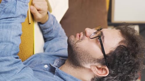 Man Lying on Couch Reading Book