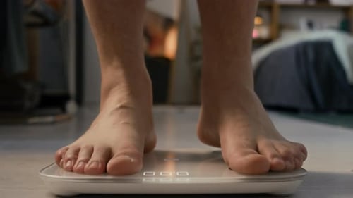 Man Stepping on Scale