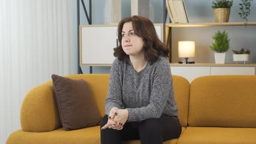 Woman Sitting Alone on Couch Looking Anxious