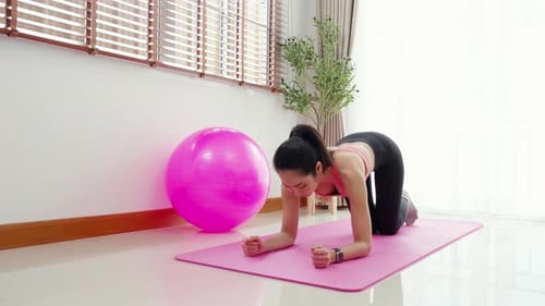 Woman Does Plank Exercise on Yoga Mat