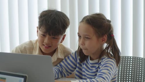 Two Children Looking at Computer Screen Indoors