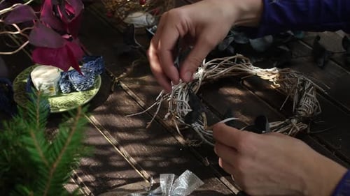 Woman's Hands Crafting a Winter Wreath