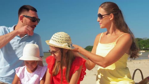 Family enjoys sandwiches on bright sunny beach day