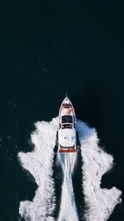 Ein leistungsstarkes Schnellboot durchquert das offene Meer und hinterlässt eine markante Welle, die von oben eingefangen wurde