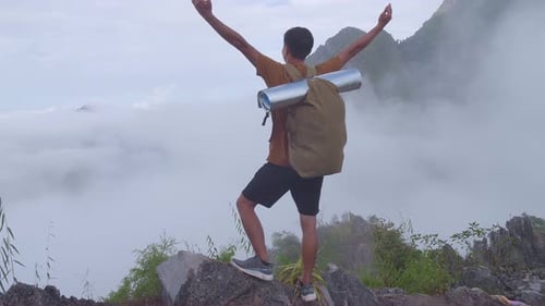 Asian Hiker Male Reaching Up Top Of Foggy Mountain And Raising His Hands