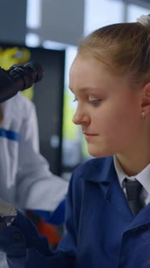 Teenage Girl Working With Microscope in Science Lab