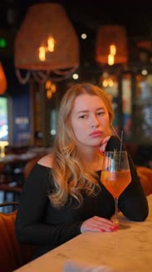 Woman at Table with Wine Enjoying Drink and Ambiance