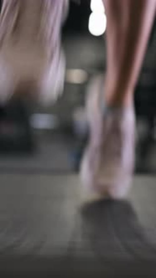Sports shoes for a girl running on a treadmill. Vertical close up