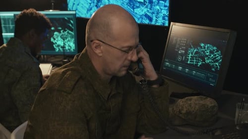 Military Personnel Working on Computers in Dark Office