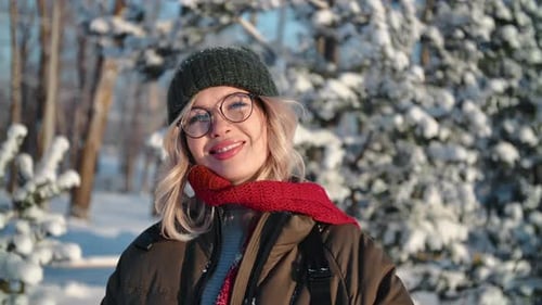 Portrait Happy Young Woman in Warm Hat and Scarf Posing at Sunny Winter Snow Forest Closeup