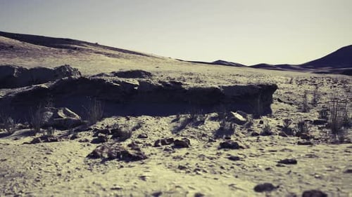 Strippeddown Arid View Featuring Eroded Ground and Soft Hills Edges