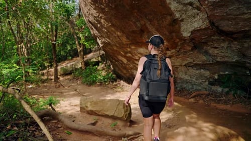 Solo Female Hiker Explores Forest Grotto on Rocky Trail Adventure Travel Active Lifestyle in Nature