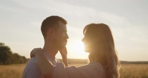 Young Attractive Couple Having a Date at Sunset in a Golden Wheat Field