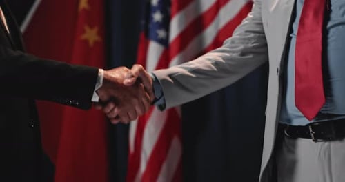 Business Handshake with American and Chinese Flags