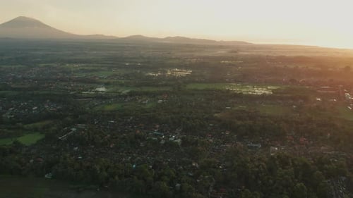 Dreamy bright sunrise above central Bali with silhouette view of Mount Agung, aerial