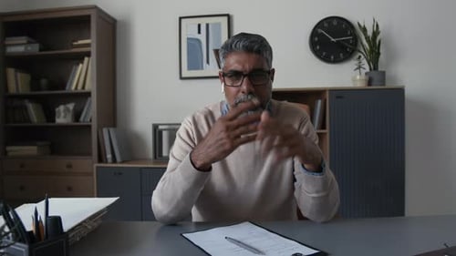 Man at Desk Talks and Signs Document