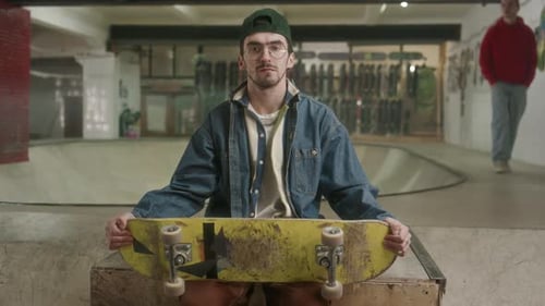 Young Adult Skater Poses at an Indoor Skatepark
