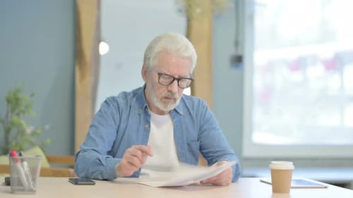 Old Man Reading Documents in Office, Paperwork
