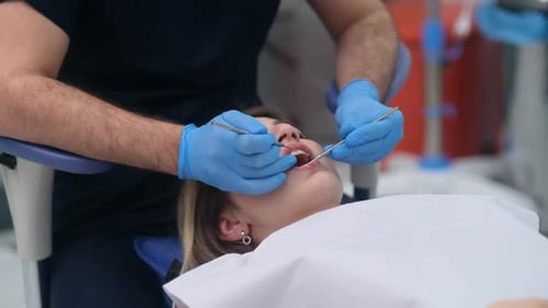 Tooth Treatment in Modern Dentistry Clinic Doctor in Rubber Gloves Checking Cavity