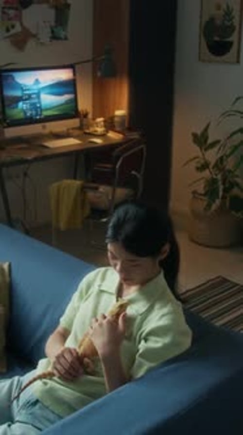 Femme chinoise caressant un lézard Agama assis sur la poitrine à la maison