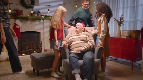 Family Gathers Around Grandfather at Christmas Indoors