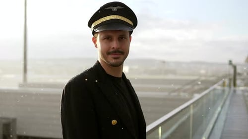 Handsome Pilot in Uniform Standing at Airport