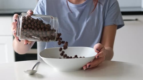 Young Adult Pouring Cereal into a Bowl