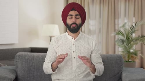 Man with Turban Sits with Hands Open