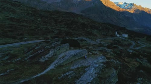 Aerial view orbiting hooded hiker with dog exploring rugged San Bernadino Pass valley countryside