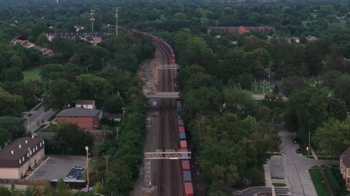 Drone Wide View of Cargo Train Crossing Near City