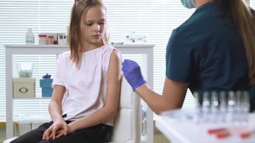 Girl Receives Arm Injection From Healthcare Professional