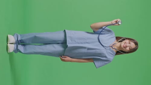 Full Body Side View Of Female Doctor With Stethoscope Crossing Her Arms And Smiling On Green Screen