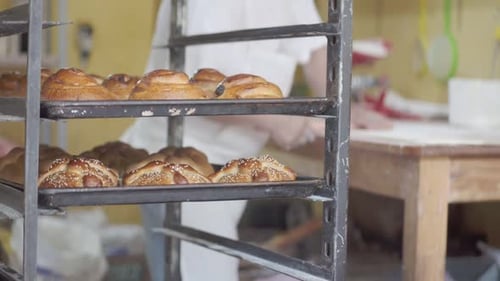 Delicious freshly baked croissant at a bakery kitchen with chef preparing dough, closeup
